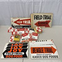 Assortment of large directional field trial signs and smaller paper ephemera arranged on table