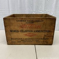 Front view of the wooden ammo crate showing 'Loaded Shot Shells Western World Champion Ammunition' text and company details.