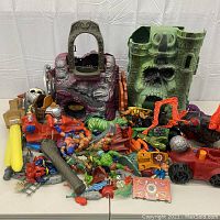 Overall view of two playsets with loose figures and accessories scattered in front