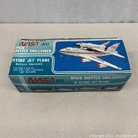Box top view showing NASA 905 Space Shuttle Challenger flying jet plane toy branding and image of the toy.