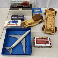 Lot overview showing all vehicles including wooden cars, diecast airplane, boxed vehicle models, and 1948 Santa Fe train.
