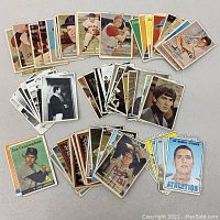 Overview of mixed baseball and Beatles trading cards laid out in groups