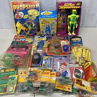 Full lot laid out on a bed, showing all boxed and loose items from helicopter toy to collectible model cars and more.