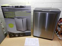 Photo of the stainless steel sensor trash can and its retail box showing product branding and features.