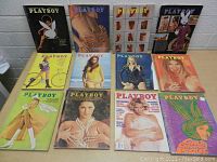 12 Playboy magazines arranged in two rows on table showing colorful vintage covers