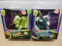 Two boxed 3D wall lights showing Michaelangelo's and Leonardo's hands with weapons, in original packaging with TMNT branding.