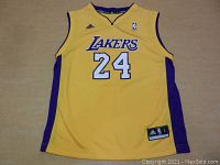 Front view of yellow Adidas Kobe Bryant Lakers jersey with purple side panels and number 24 on front.