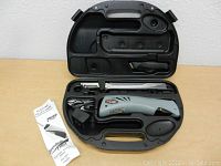 Electric fillet knife, charger, blade, and instruction manual in black plastic carrying case