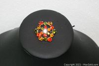 Front view of the rhinestone brooch showing the color and arrangement of stones in red, orange, yellow, and green.
