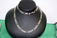 Full view of men's chain necklace displayed on black bust with clasp visible.