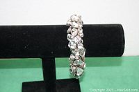 Front view of clear rhinestone bracelet displayed on black jewelry stand showing variety of rhinestone shapes and sparkling appearance