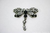 Dragonfly brooch front view showing black and clear rhinestones detail and movable tail