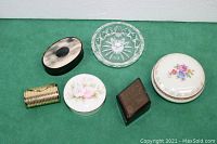 All six small containers arranged on green fabric background: 4 trinket boxes, 1 pill box, and 1 ring holder.