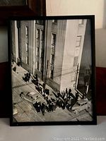 Framed vintage black and white photograph showing pedestrians and vintage cars on a Toronto street near a large stone building.