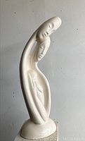 Front view of large vintage ceramic figurine showing three stylized figures with elongated limbs and faces.