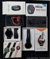 Six items laid out: four branded boxes and two loose watches