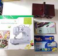 Photo showing household sewing machine UFR-705 box, wooden sewing box, handheld sewing machine box, and thread stand box.