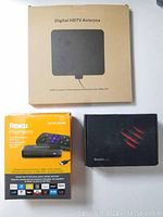 Boxed digital HDTV antenna, Roku Premiere 4K HDR box, and Pendoo Android TV Box box.