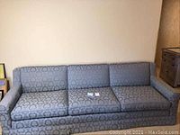 Full view of 8 foot blue damask sofa with three cushions and padded arm rests