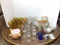 Overview of glassware assortment including amber glassware, clear crystal wine glasses, Pyrex lidded bowls, Murano ashtray, and additional kitchen items.