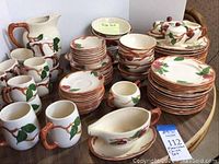 Full lot grouping of cups, plates, bowls, pitcher and serving pieces on table