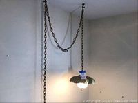 Swag light pendant hanging on ceiling chain showing overall fixture and wall shadows