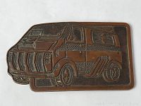 Front view of the copper brass belt buckle showing detailed van design with textured surfaces and raised relief.