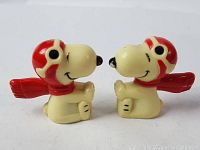 Two Snoopy Red Baron figures facing each other showing side profiles