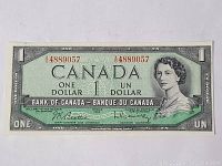 Front view of the 1954 Canadian one dollar note with serial number 4889057, showing portrait of Queen Elizabeth II and signatures.