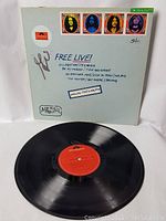 Front and back cover of 'Free Live!' vinyl LP showing band member portraits and track listing with signatures.