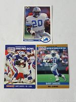 Three Barry Sanders football cards including 1990 Pro Bowl, 1989 Rookie of the Year, and Upper Deck card in Detroit Lions uniform