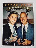 Front view of 1992-93 Upper Deck hockey card featuring Gordie Howe and Wayne Gretzky posing with hockey pucks and text 'Gordie Howe Mr. Hockey and The Great One'.