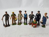 Front-facing photograph of the complete set of 8 antique Britain's lead figures, showing each figure standing or squatting with painted details and bases.