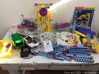 Full lot on table with various components including vehicles, ramps, control units and assorted building pieces