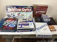 Photo of eight boxed games showing front covers and game titles, arranged on table.