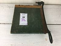 Full view of the Milton Bradley paper cutter showing green grid cutting surface and metal cutting arm.