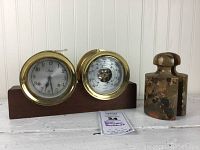 Overall view of both brass instruments on wooden base with one marble bookend