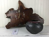 Photo showing the dark brown live edge wood clock and art pottery vase together from front angle