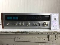 Full front view of tuner showing display, knobs and wood veneer sides