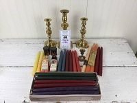 Three brass candlesticks and assorted candles including Mole Hollow and Yankee Candle varieties across colors and sizes: red, green, blue, purple, yellow tapers along with Halloween candles.