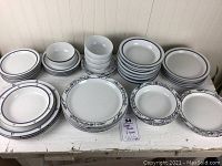 Full assortment of 40 pieces showing all plates and bowls in three distinct blue/white china patterns arranged on table