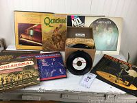 Photo showing multiple LP album covers and a box of 45rpm records with some sleeves.