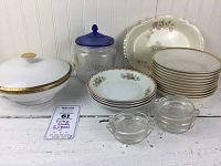 Overview of lot on white surface showing covered vegetable dish, Hazel Atlas cookie jar, Homer Laughlin platter, floral rimmed plates, and clear glass custard cups.