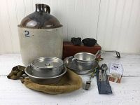 Photo of the full lot showing stoneware jug, wooden box, mess kit, utensils, metal whistle, and stones