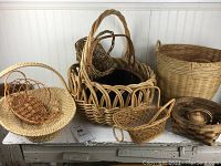 Photo showing all 10 woven baskets arranged on a table. Includes varying sizes and styles, mostly in natural brown woven materials.
