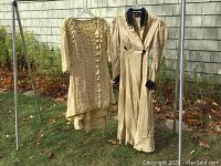 Full view of both garments hanging on outdoor rack against shingled wall