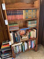 Front view of the antique wooden bookshelf filled with books.
