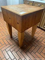 Full view of butcher block island showing end grain wood top and tapered legs