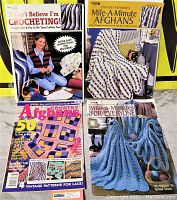 Lot of 4 crochet and afghan pattern books stacked and displayed on a bright yellow background. Covers show crochet projects including afghans and yarn with hooks.