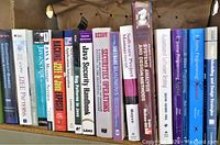 Photo of a row of software and programming books including Java, security, J2EE patterns, software engineering, and software project management topics.